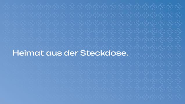 Text auf einem blauen Hintergrund: „Heimat aus der Steckdose“ in großer, weißer Schrift. Muster im Hintergrund.