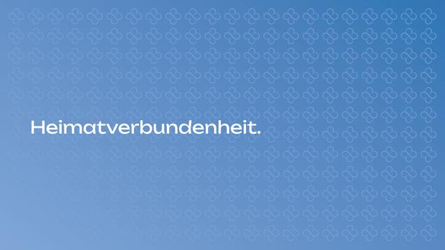 Hintergrund mit wiederholtem Blütenmuster und dem Schriftzug „Heimatverbundenheit“ in großer, heller Schrift.